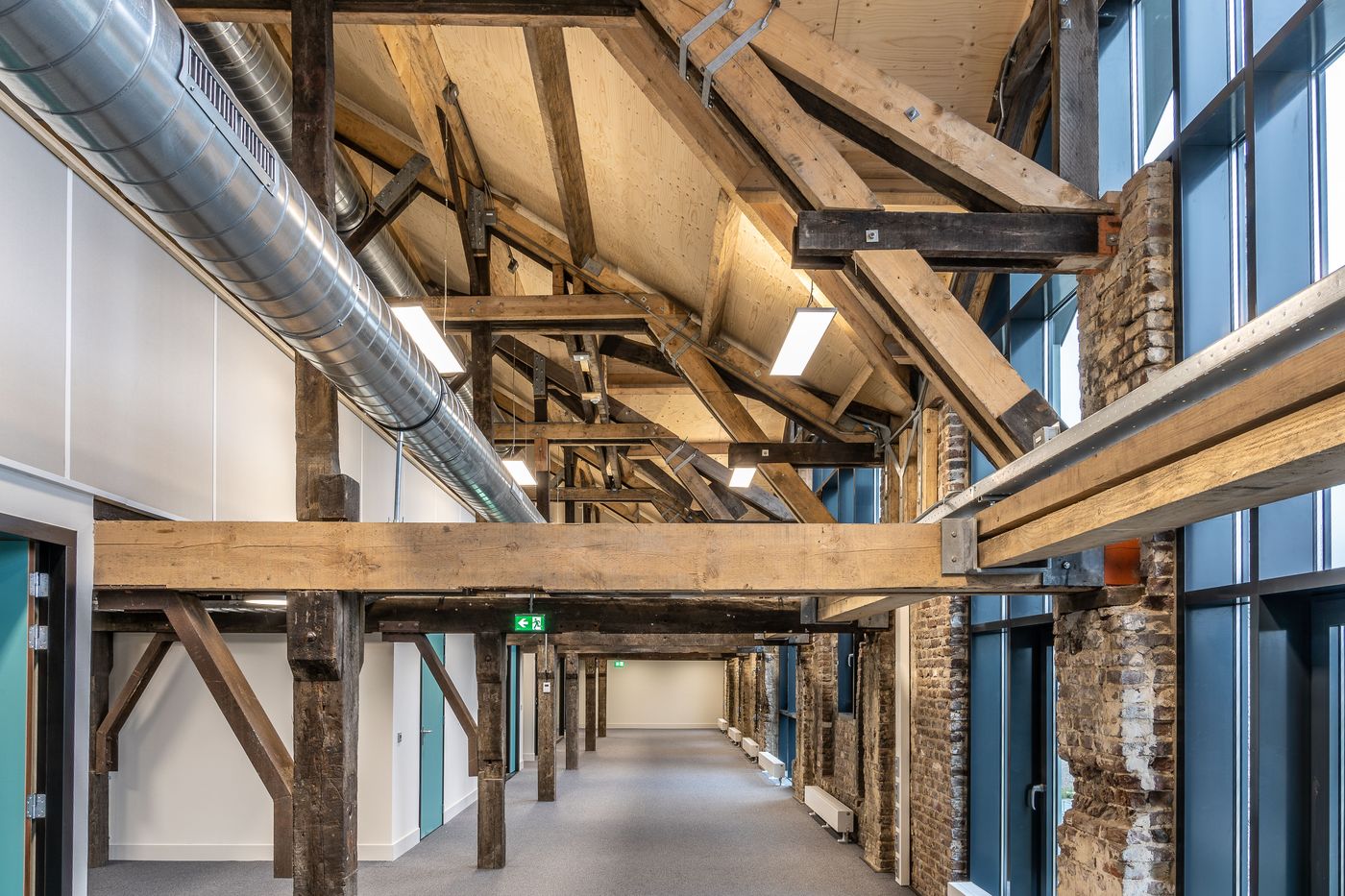 Commercial interior fit-out with exposed spiral ductwork and timber structure